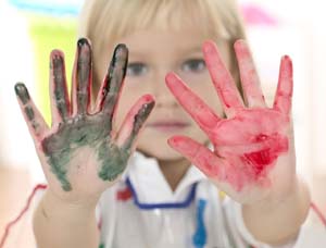 bambino che mostra le manine colorate